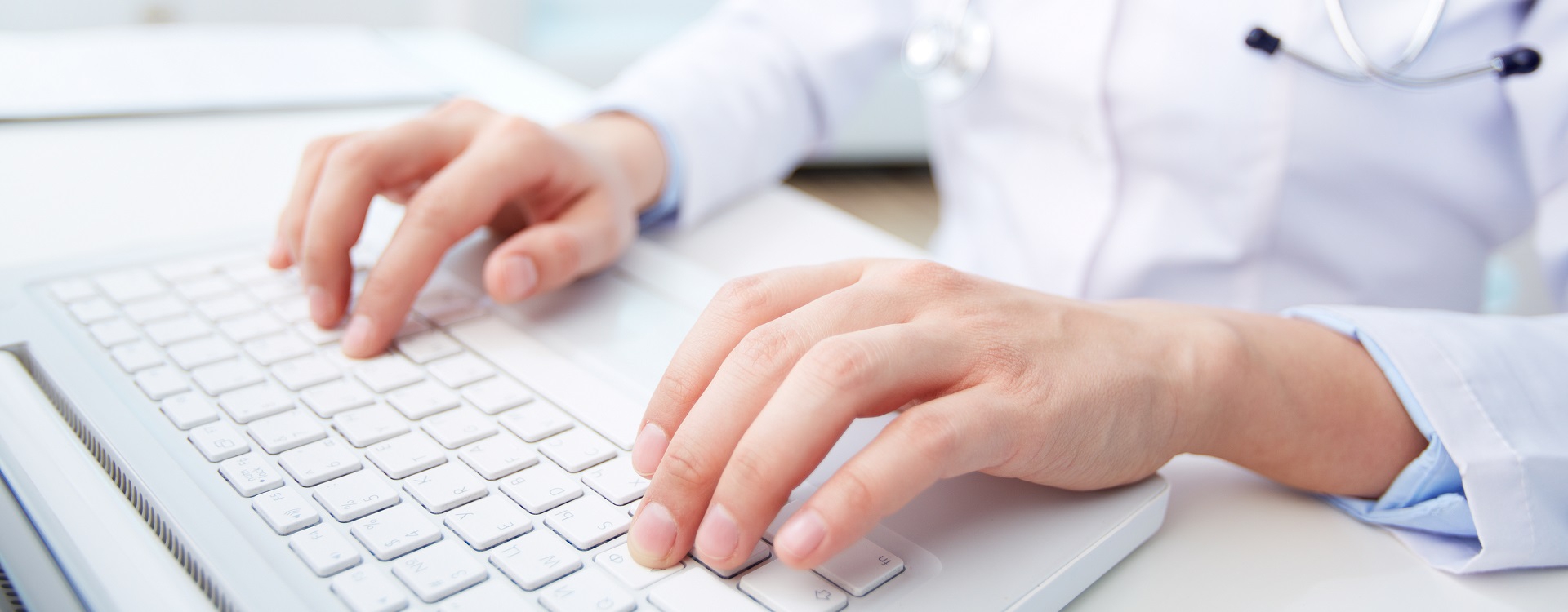 Close-up of a medical worker typing on laptop