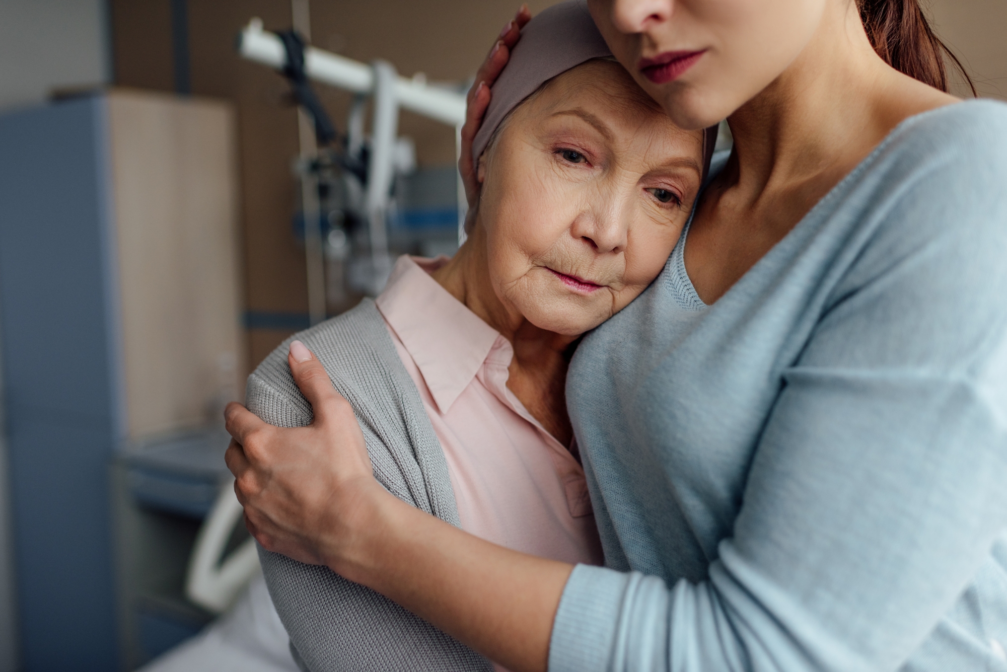 selective focus of daughter hugging sick senior mother with cancer in hospital
