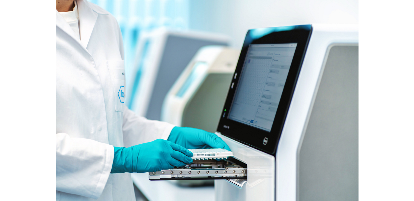  Lab tech loads a sample tray into Roche LightCycler PRO, a compact PCR system with the ACT label, My Green Lab certification