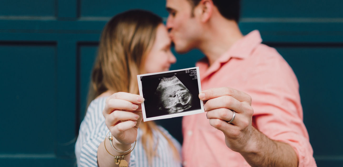 couple holding pregnancy ultrasound picture