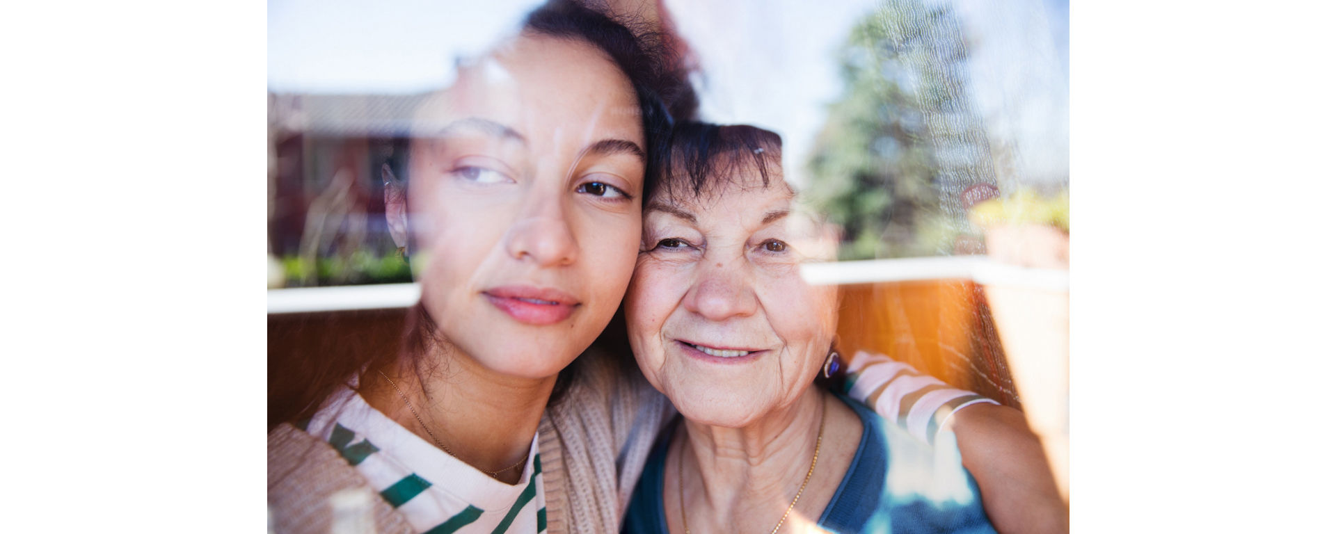 A portrait of a young woman and an older woman possibly a granddaughter and grandmother smiling together