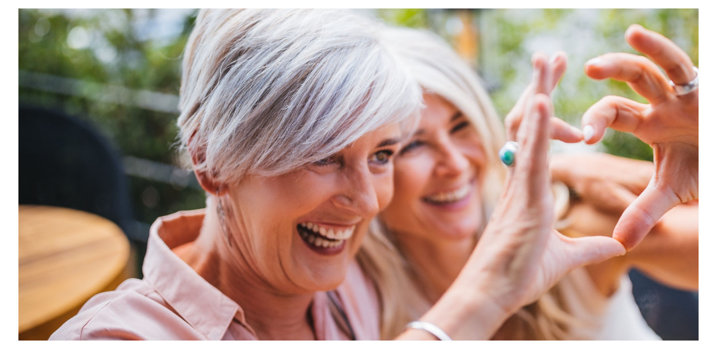 Zwei Frauen zeigen ein Herz, sie drücken die Herzgesundheit bei Diabetes und Herzinsuffizienz aus.
