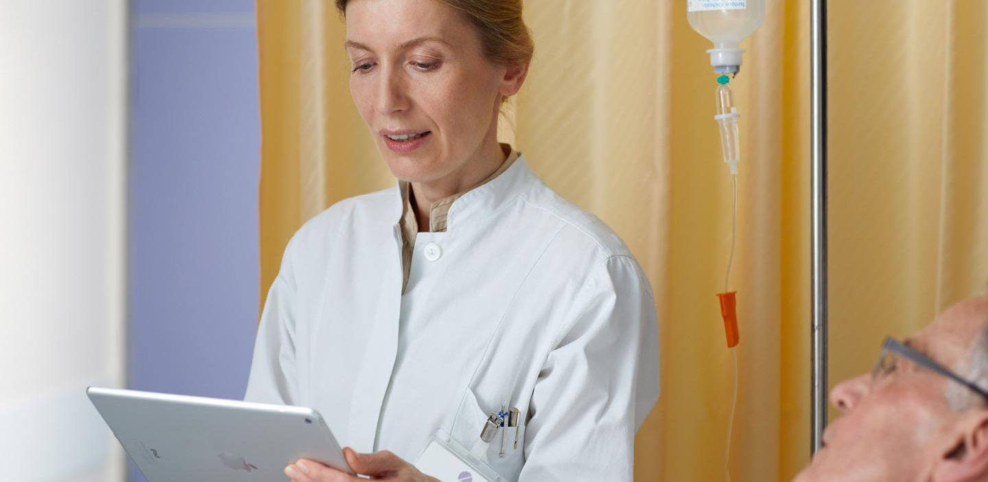Healthcare professional checking with clipboard checking on patient in hospital