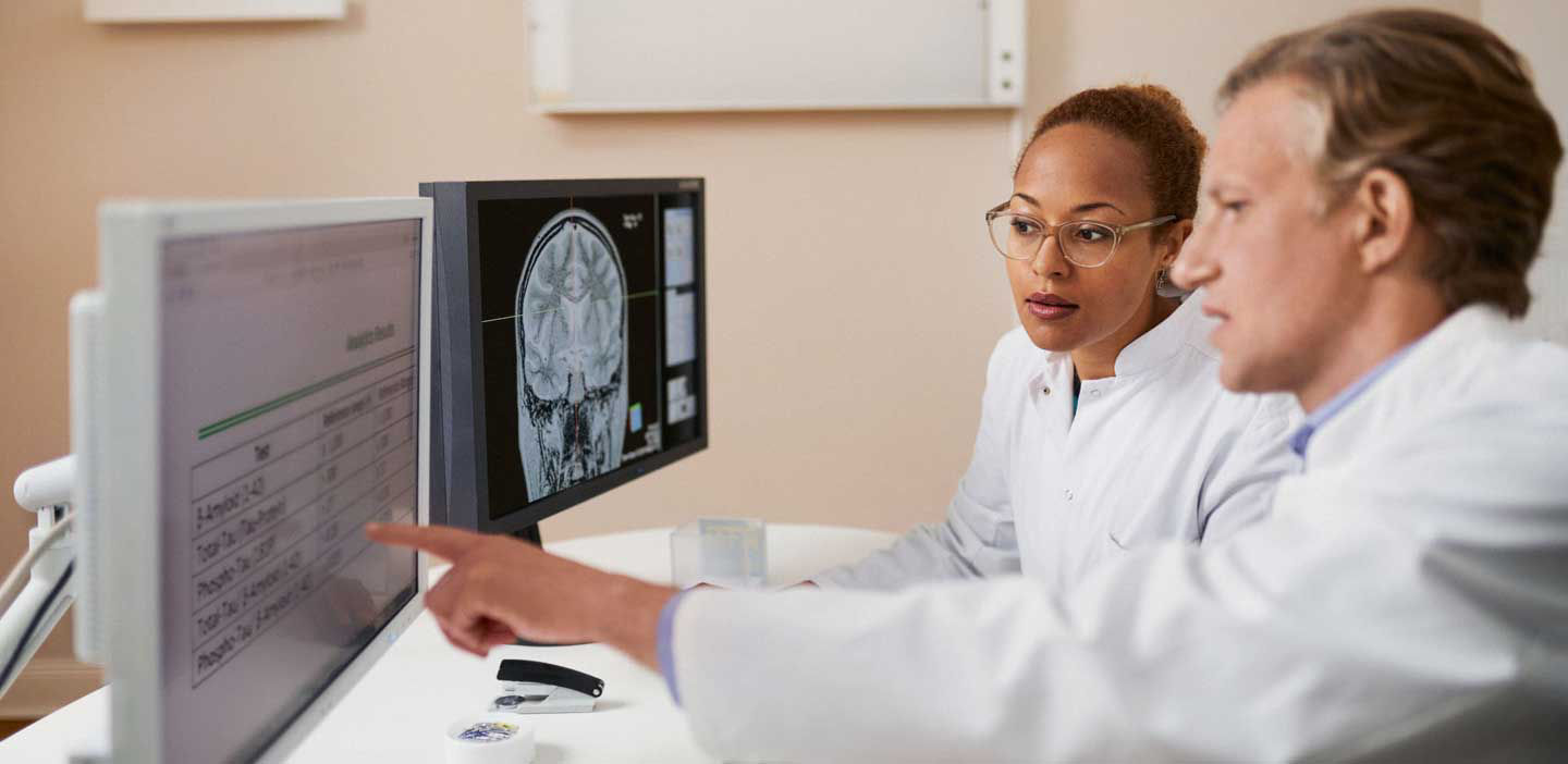 Doctor and lab technician looking at Alzheimer's Disease test results.