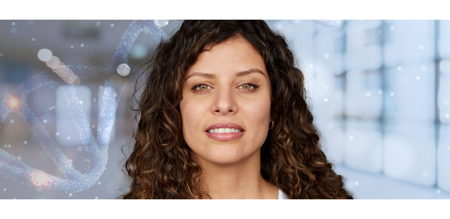 A woman wearing a white lab coat gazes into the distance