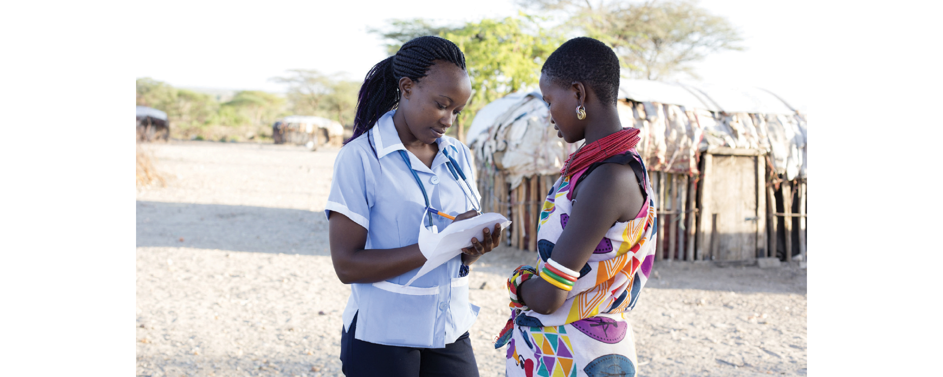A healthcare professional taking notes with a patient, demonstrating the impact of a global access program. 