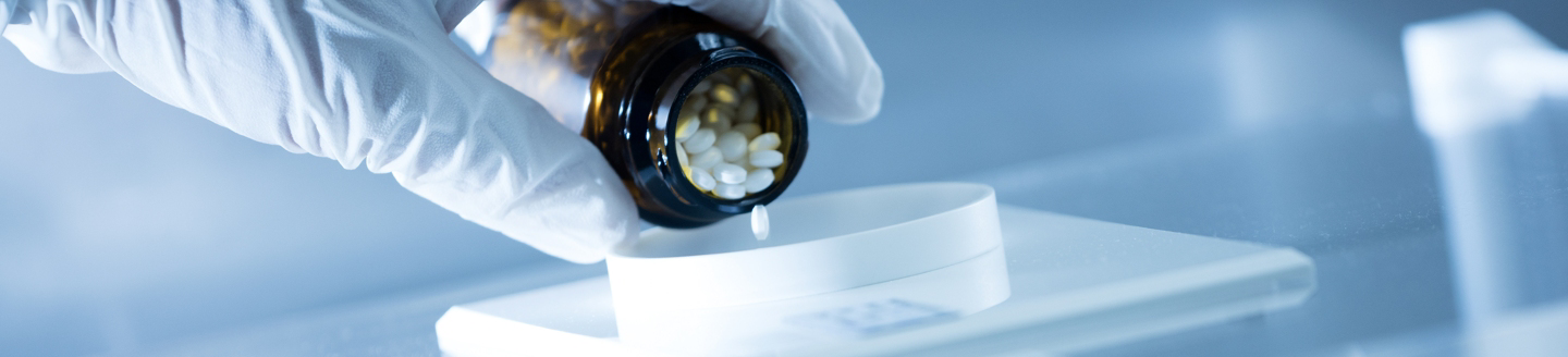 healthcare worker emptying pill bottle filled with antibiotics