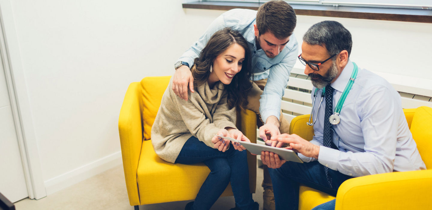 doctor consulting with parents on a couch