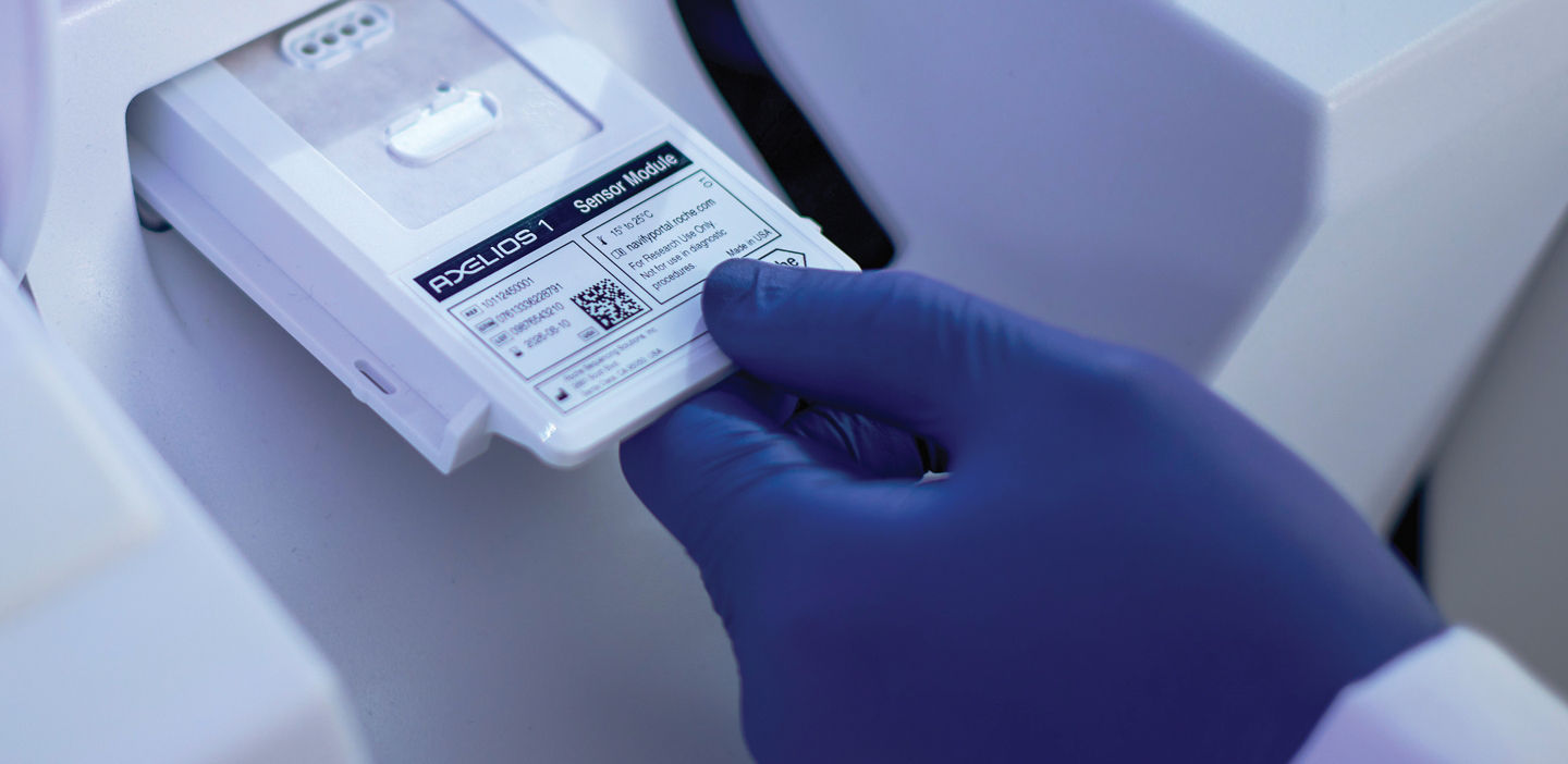 roche technician inserting a sensory module into the axelios 1
