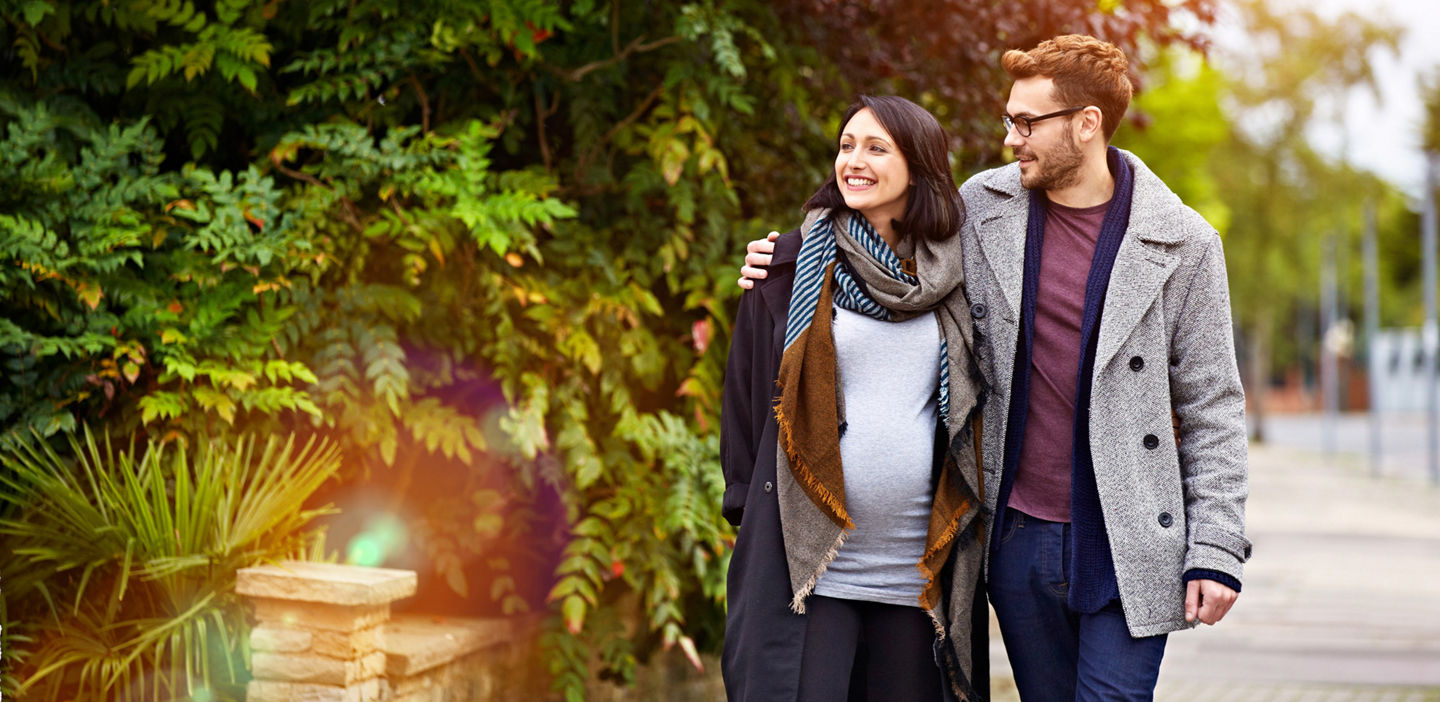 Expecting parents walking outdoors