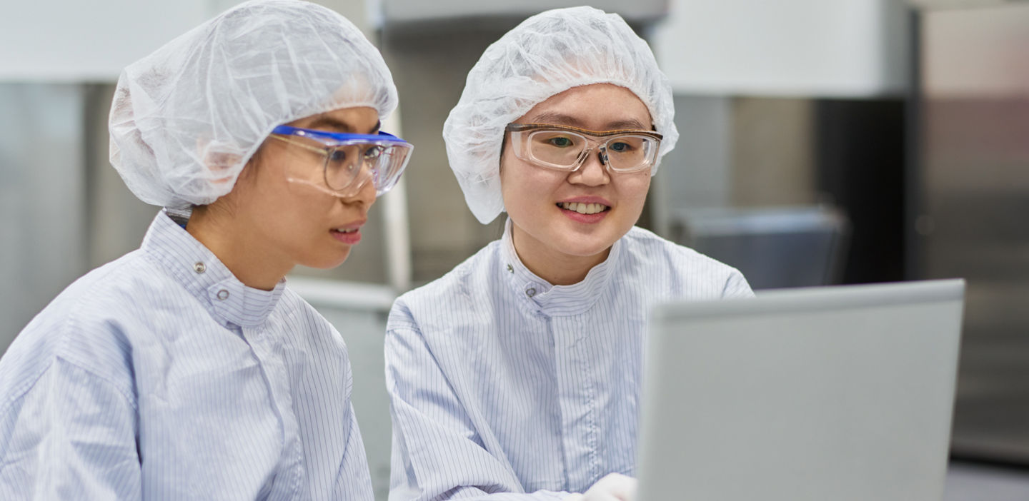 Collegues looking at the monitor screen, while working in hospital laboratory