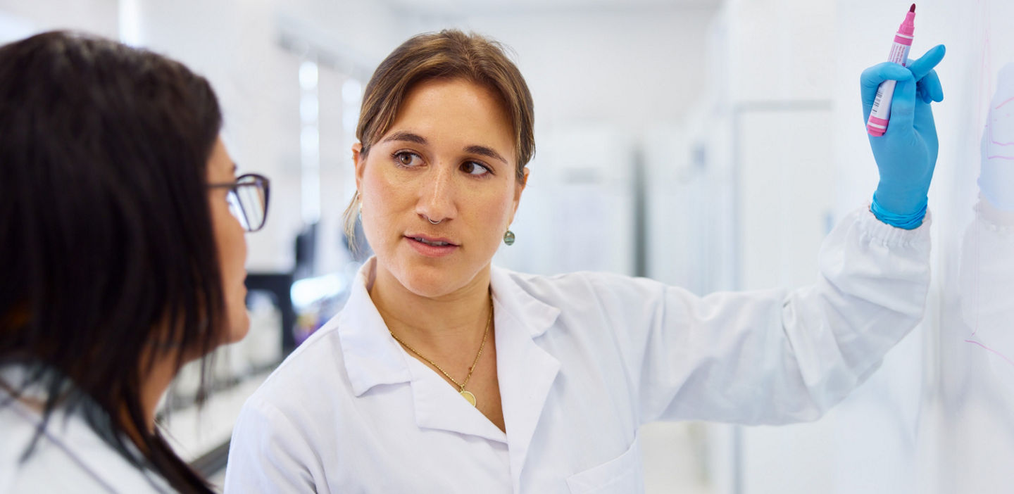 Lab staff collaborating at a whiteboard