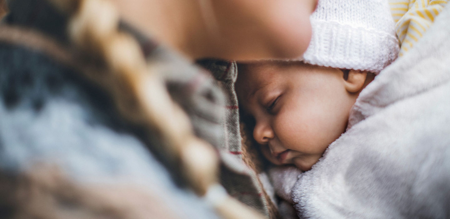 baby asleep on adult shoulder outdoors