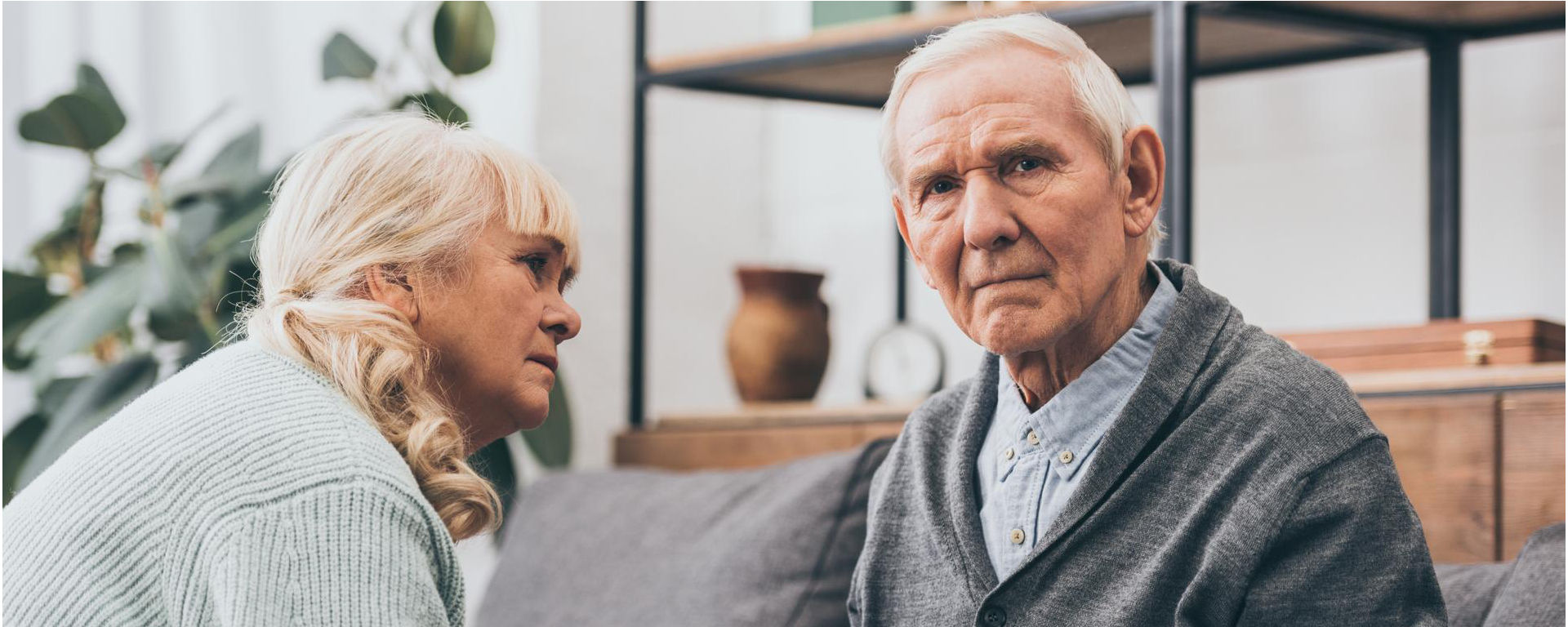 Models depicting a woman supporting her husband who is suffering from dementia in a living room