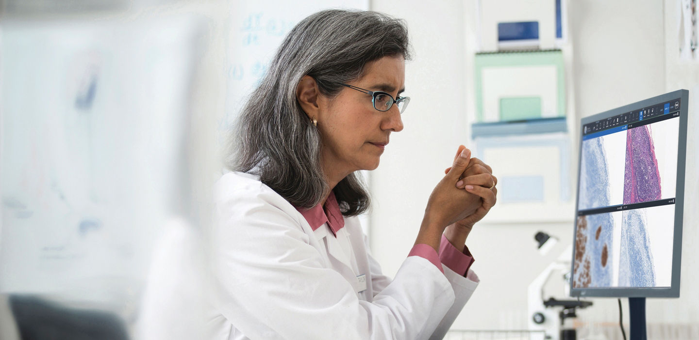 women looking at digital pathology stains on computer