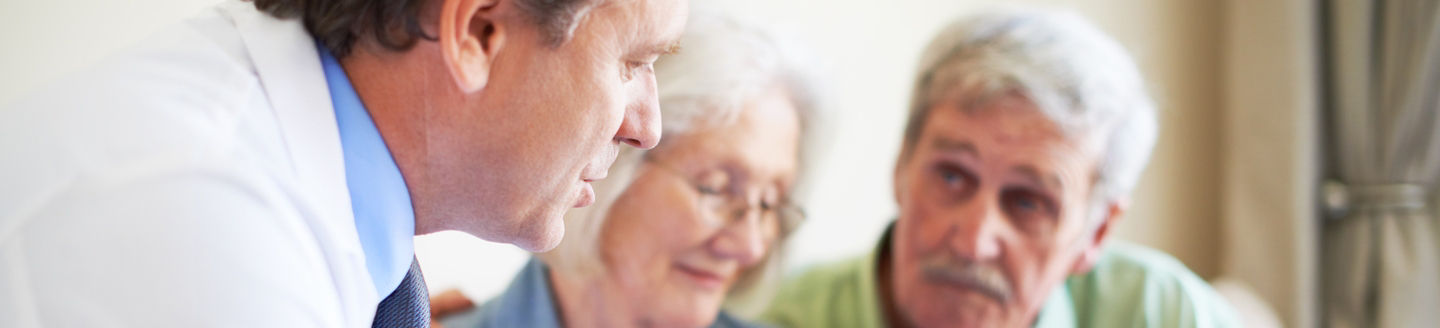 older couple in discussion with doctor in office