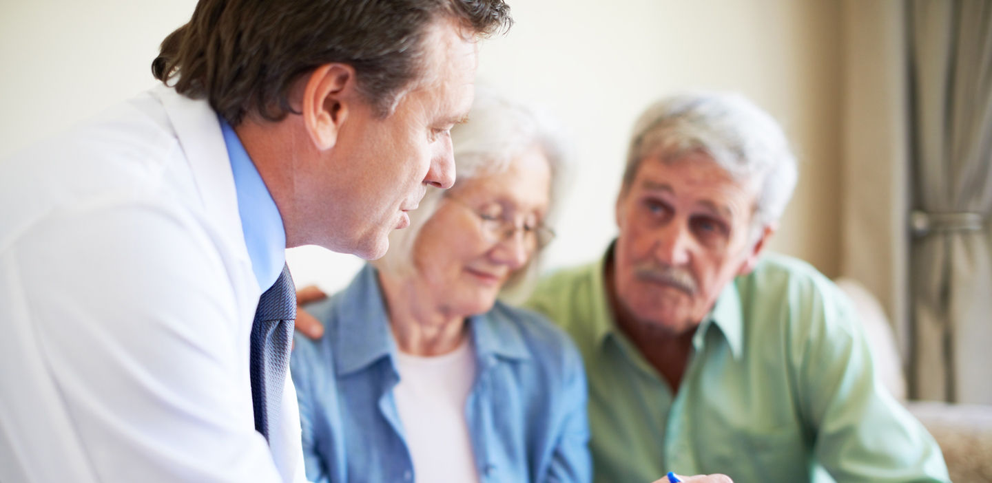 older couple in discussion with doctor in office