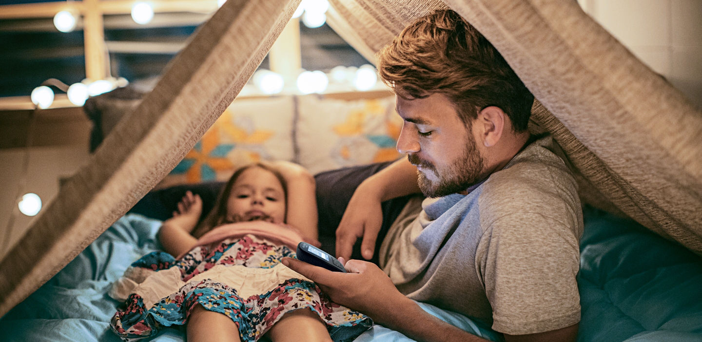 dad checking glucose in tent with daughter