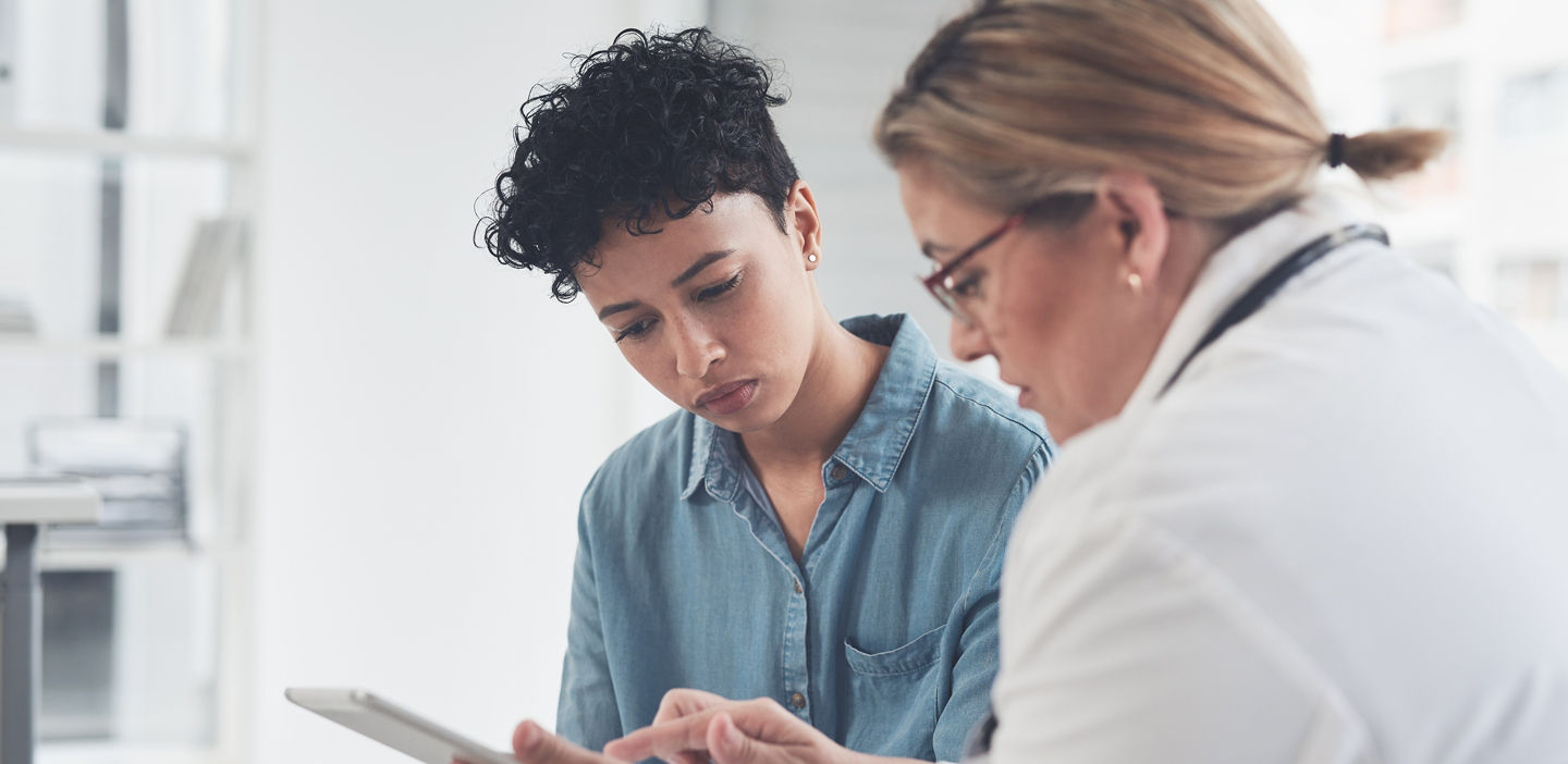female patient speaks with female doctor over tablet
